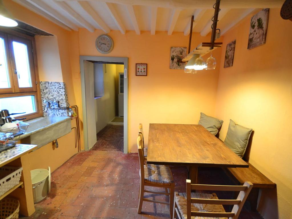 una cucina con tavolo in legno e una sala da pranzo di Belvilla by OYO characteristic Tuscan flat a Lucchio