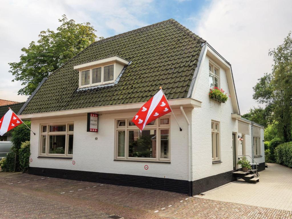 Una pequeña casa blanca con banderas rojas y blancas. en Attractive apartments within walking distance of Bergen s town centre, en Bergen