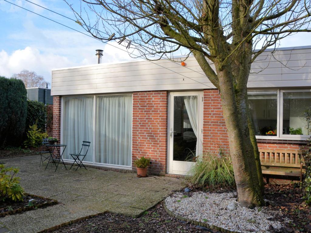 uma pequena casa de tijolos vermelhos com uma janela em Modern bungalow in South Holland em Noordwijkerhout