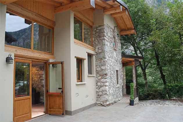 a house with a stone building with a wooden roof at Agriturismo BioBiò in Vobarno