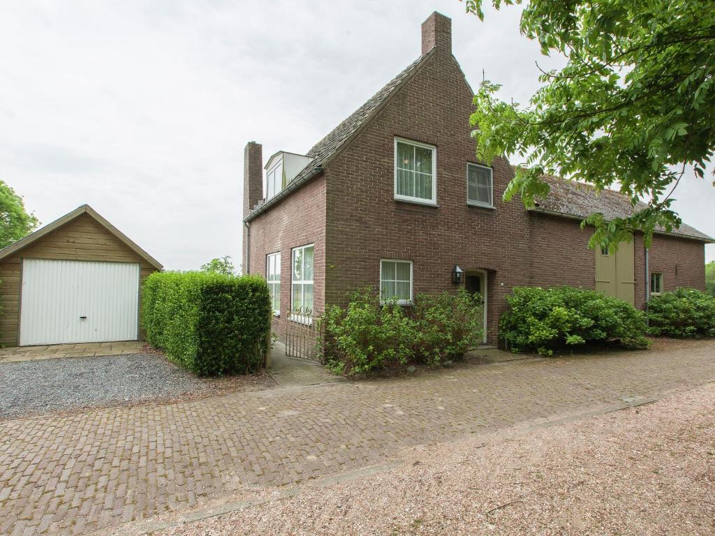 een stenen huis met een witte garage bij from the Zealand coast and 20km from Brugge in Aardenburg