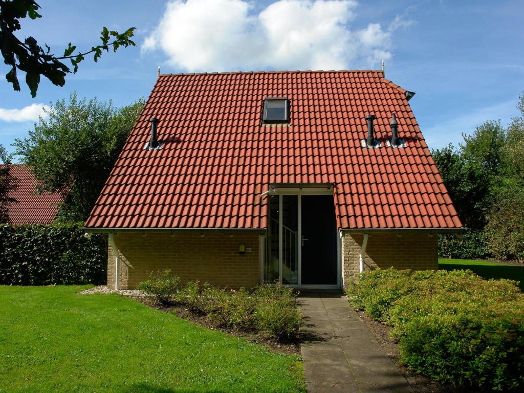 een huis met een oranje dak en een deur bij Modern Holiday Home in Trecase with Fireplace in Westerbork