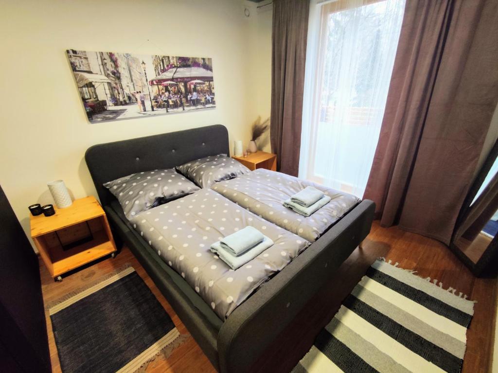 a small bed in a room with a window at Apartman Park Žilina & Free Parking in Žilina
