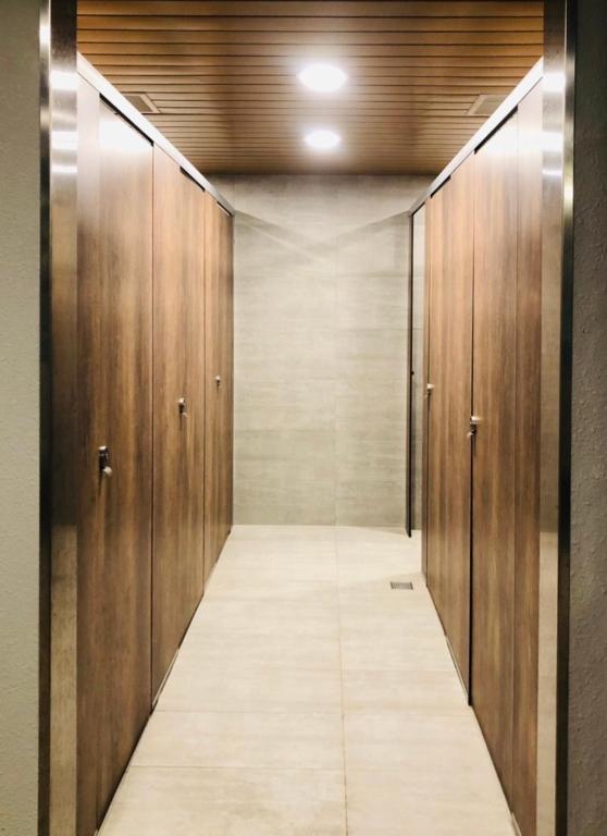 a corridor with wooden doors in a building at Single inn- KAOHSIUNG LINSEN in Kaohsiung