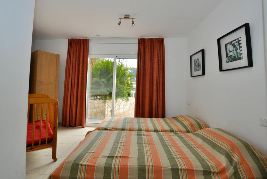 a bedroom with a bed and a large window at Villa Talia in Lloret de Mar