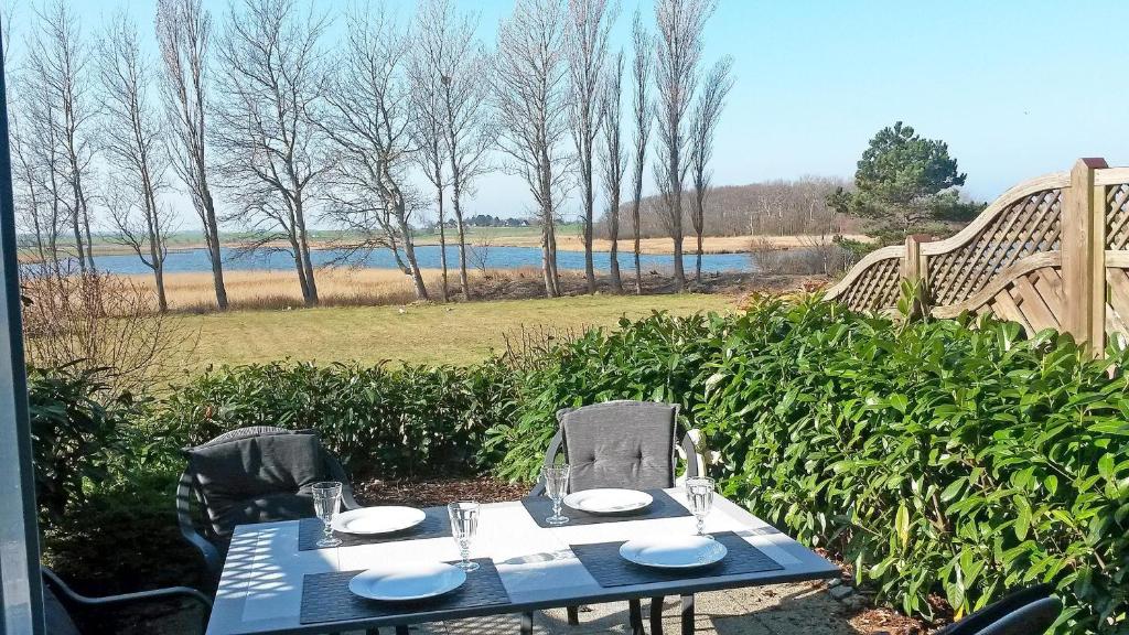 a blue table and chairs with a view of a lake at Seepark Seepark 3f in Heiligenhafen
