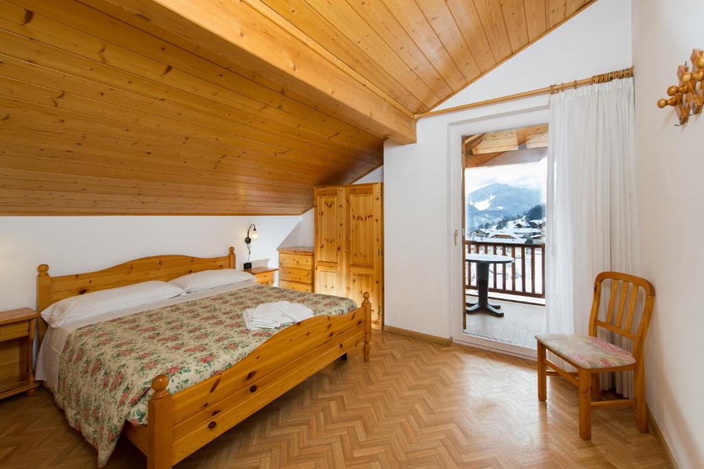 sypialnia z łóżkiem i balkonem w obiekcie Residence Villa Boschetto w mieście Carano