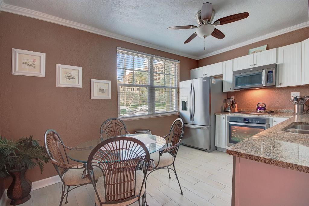 a kitchen with a table and chairs and a ceiling fan at Clearwater Beach Suites 102 condo in Clearwater Beach