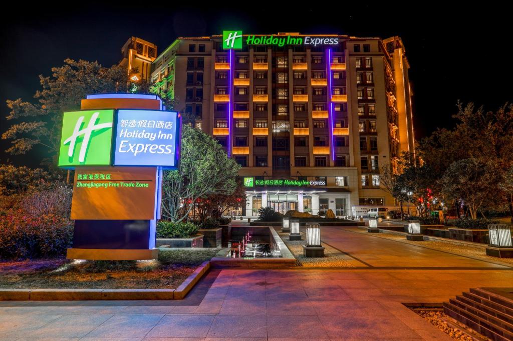 a hotel with a sign in front of a building at Holiday Inn Express Zhangjiagang Free Trade Zone, an IHG Hotel in Zhangjiagang