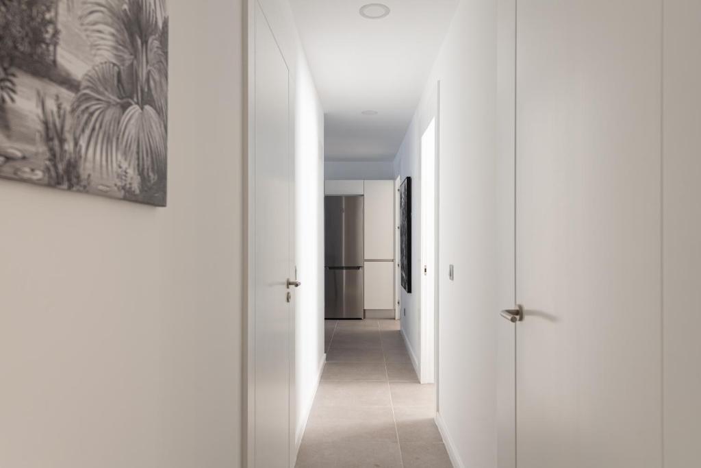 a hallway with white walls and a hallway with white doors at Royal Flats in Las Palmas de Gran Canaria