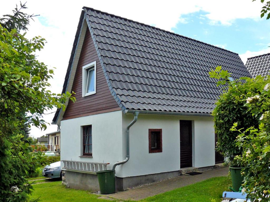 a white house with a brown roof at Ferienhaus Boddenkieker in Freest