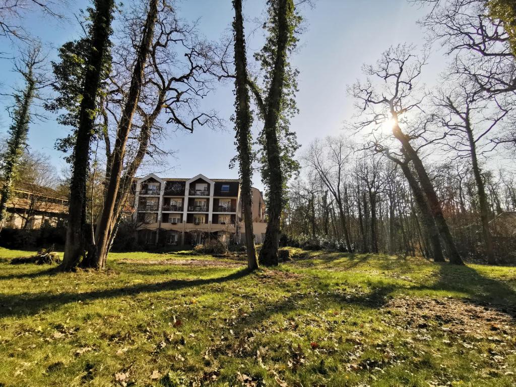 a building in the middle of a field with trees at Residence Des Sources in Amnéville