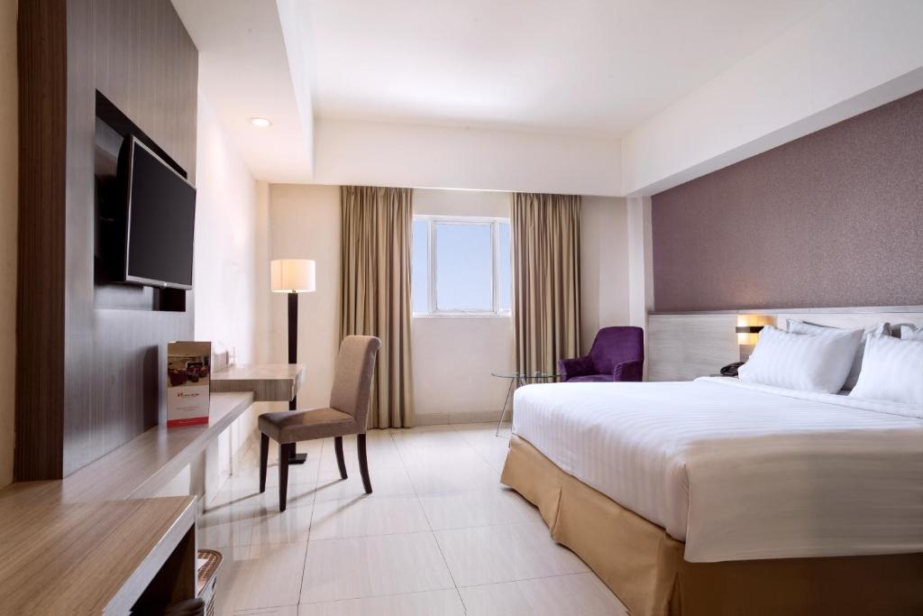 Postel nebo postele na pokoji v ubytování Swiss-Belinn Cibitung
