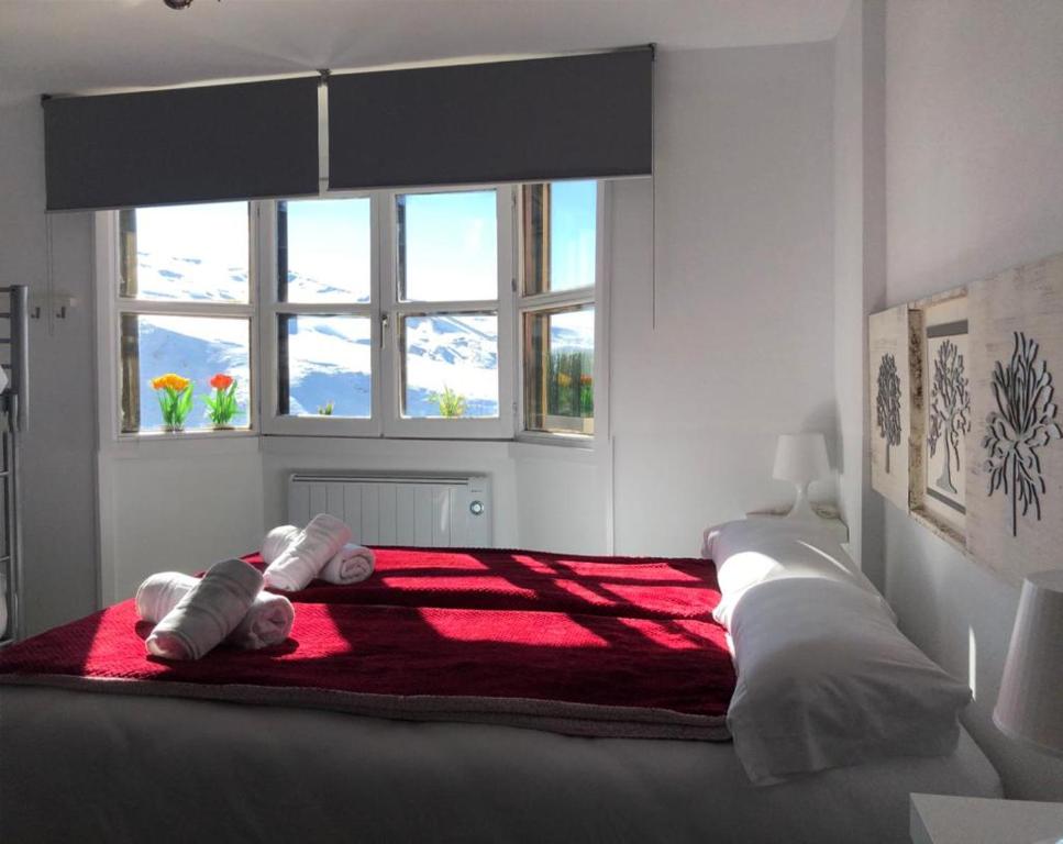 Un dormitorio con una cama grande con dos animales de peluche. en IMEDA Estudios LOS VALLES CON PARKING, en Sierra Nevada