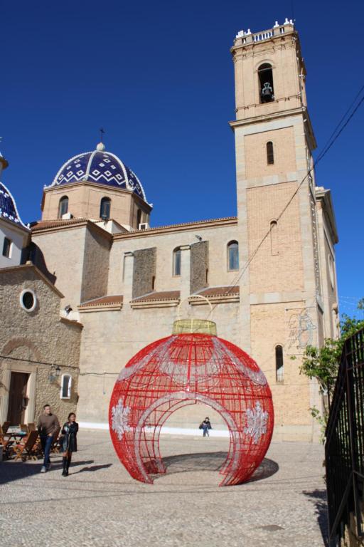 a red object in front of a building with a tower at Hostal Fornet Altea in Altea