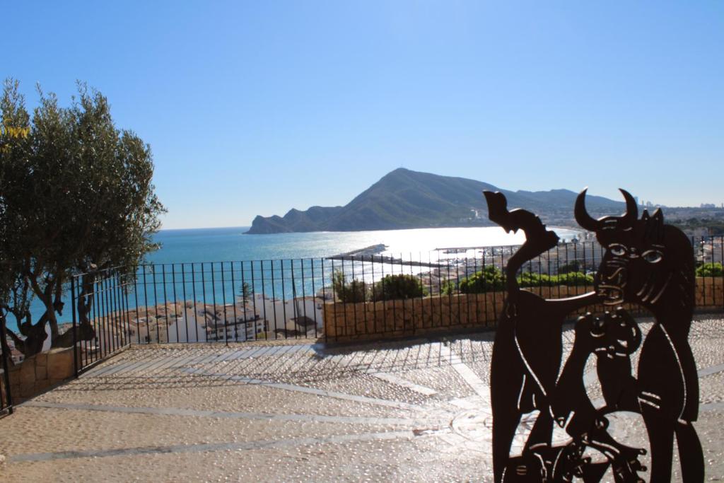 a statue of a person riding a bike next to the ocean at Hostal Fornet Altea in Altea
