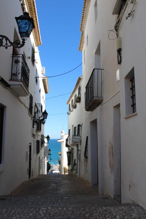 an alley with a view of the ocean from between buildings at Hostal Fornet Altea in Altea