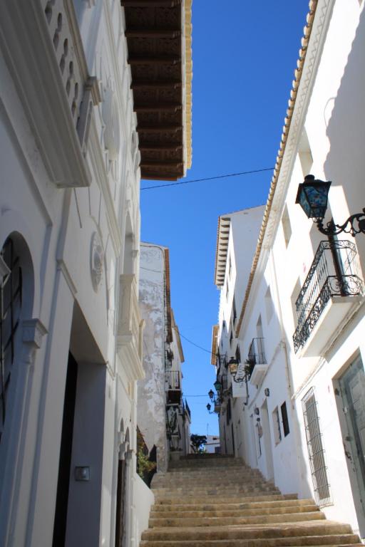 an alley with stairs in a town with a blue sky at Hostal Fornet Altea in Altea