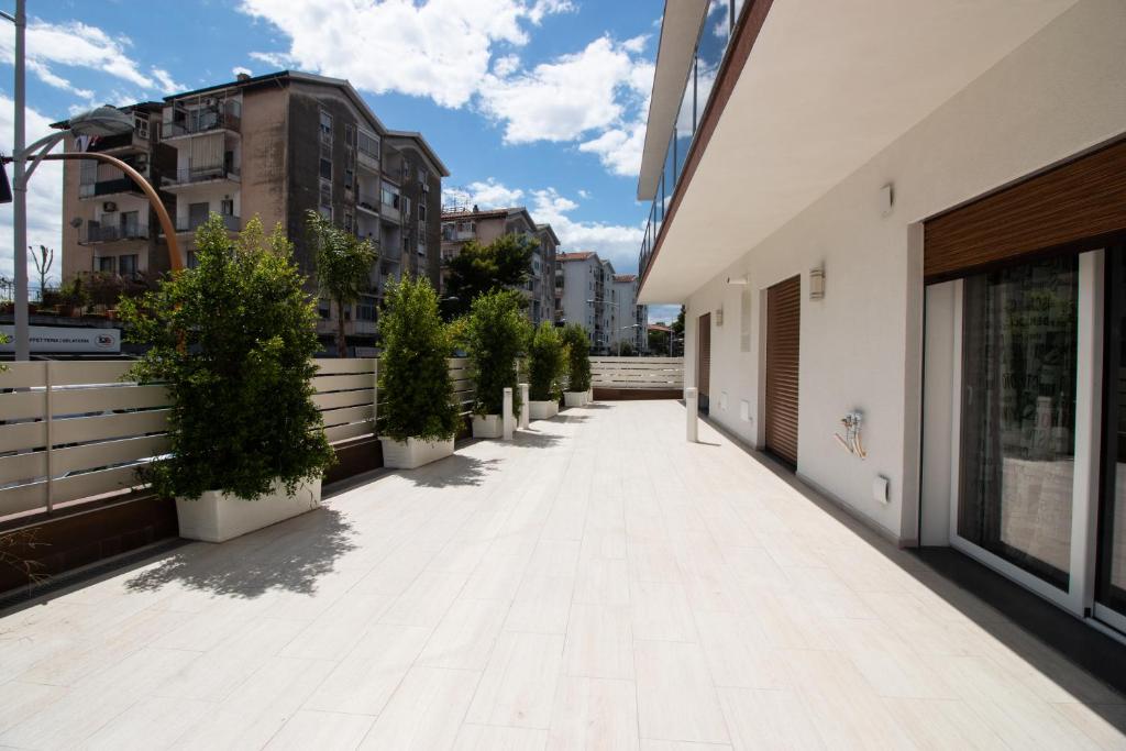 an empty walkway in a building with potted plants at Independence House Holiday in Catania