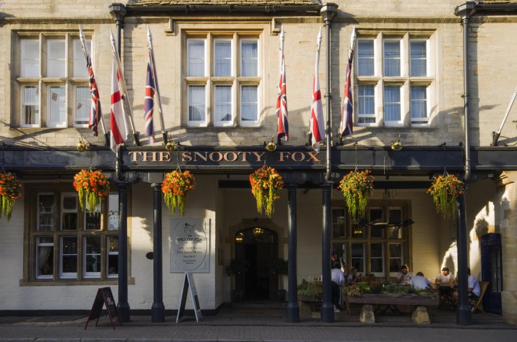 um edifício com bandeiras na frente em The Snooty Fox em Tetbury