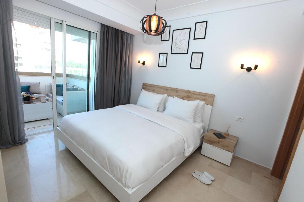 a bedroom with a large white bed and a window at Joumaya White & See in Casablanca