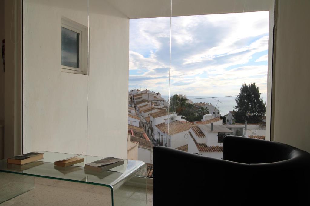 a dining room with a glass table and a large window at Hostal Fornet Altea in Altea