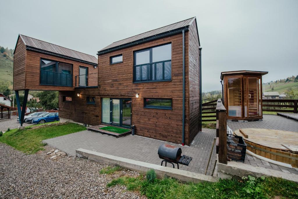 a wooden house with a bench in front of it at Orion Apartments in Lunca de Sus