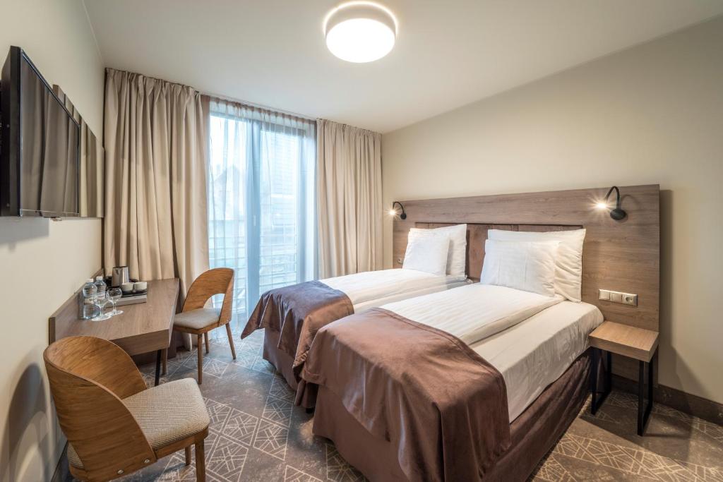 Postel nebo postele na pokoji v ubytování Wellton Riverside SPA Hotel