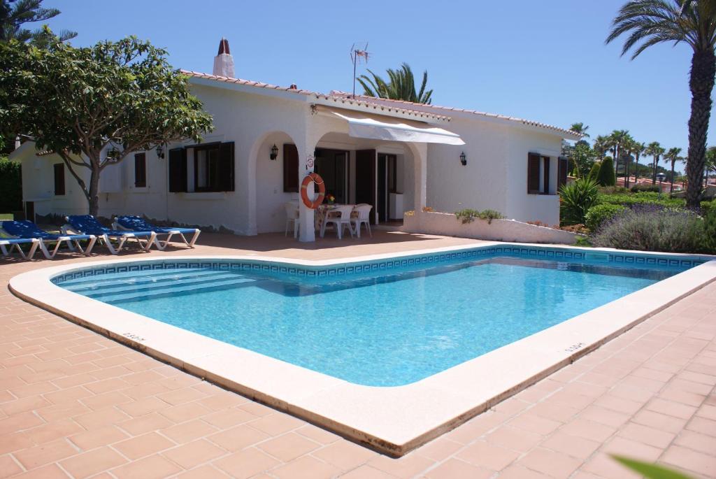 a villa with a swimming pool in front of a house at Villa Isabel in Son Bou