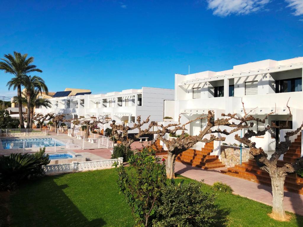 een uitzicht op een resort met een zwembad en palmbomen bij Apartamentos Els Romers Benicarló-Peñíscola in Peñíscola