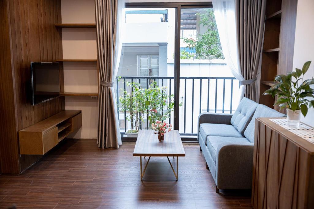 Alaya 10 Apartment في هانوي: غرفة معيشة مع أريكة وطاولة