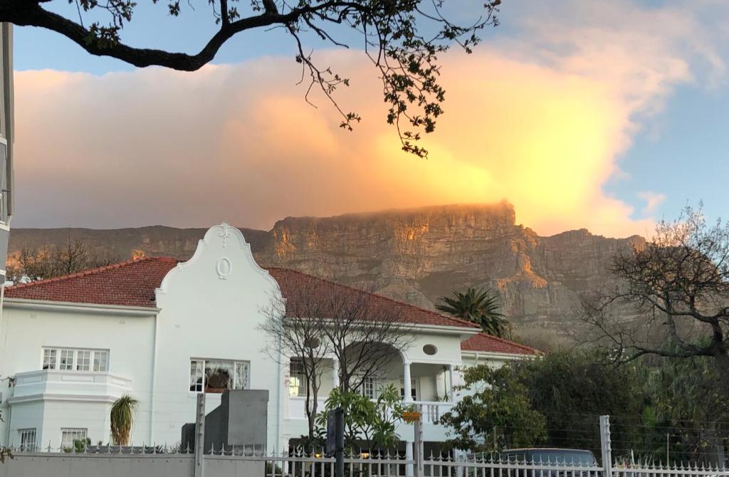 a house with the table mountain in the background at Mountain Manor Guest House & Executive Suites in Cape Town