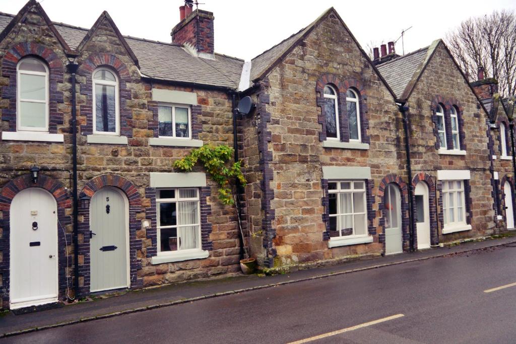 a brick building with white doors and windows on a street at Rosedale Cottage in Rosedale Abbey