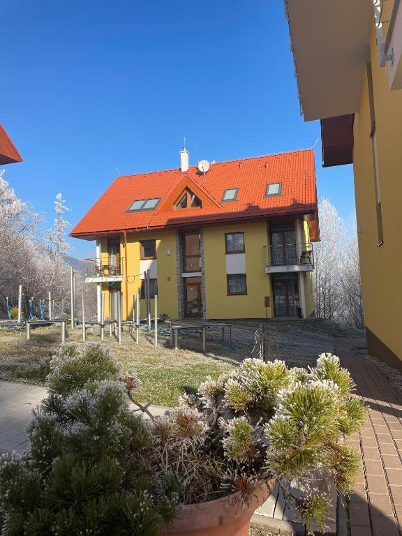 a yellow and orange house with an orange roof at Resort Vila Credo in Starý Smokovec