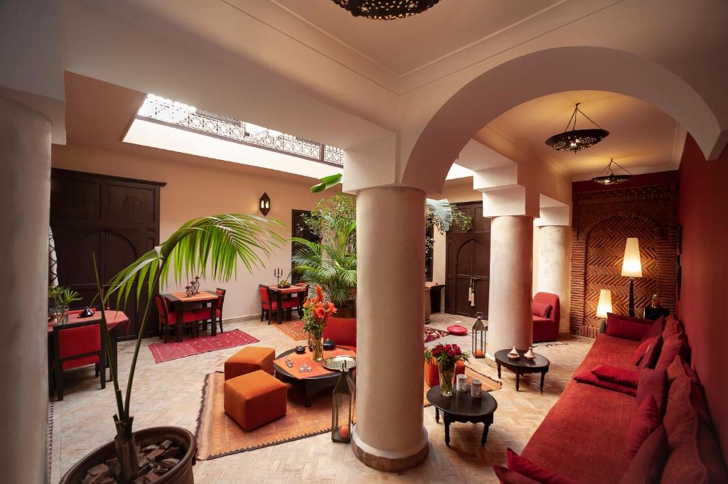 a large living room with red couches and tables at Riad Boussa in Marrakech