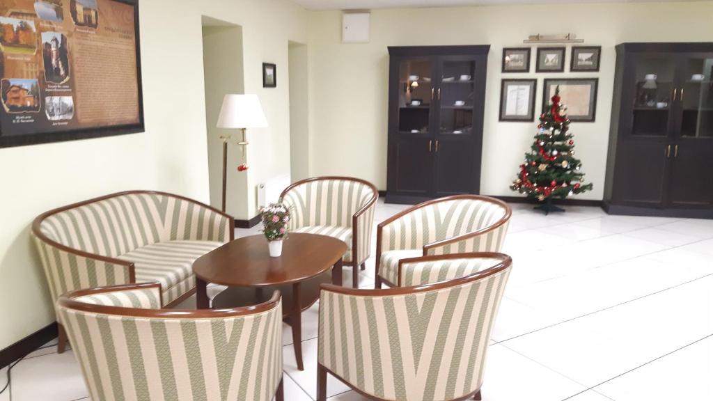a room with a table and chairs and a christmas tree at Friedental Hotel in Pushkin