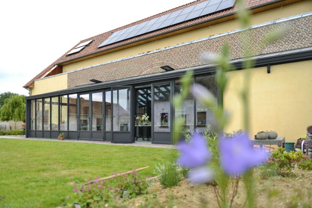 um edifício com grandes janelas de vidro e um quintal em B&B O Chocolat Cho em Sint-Pieters-Leeuw