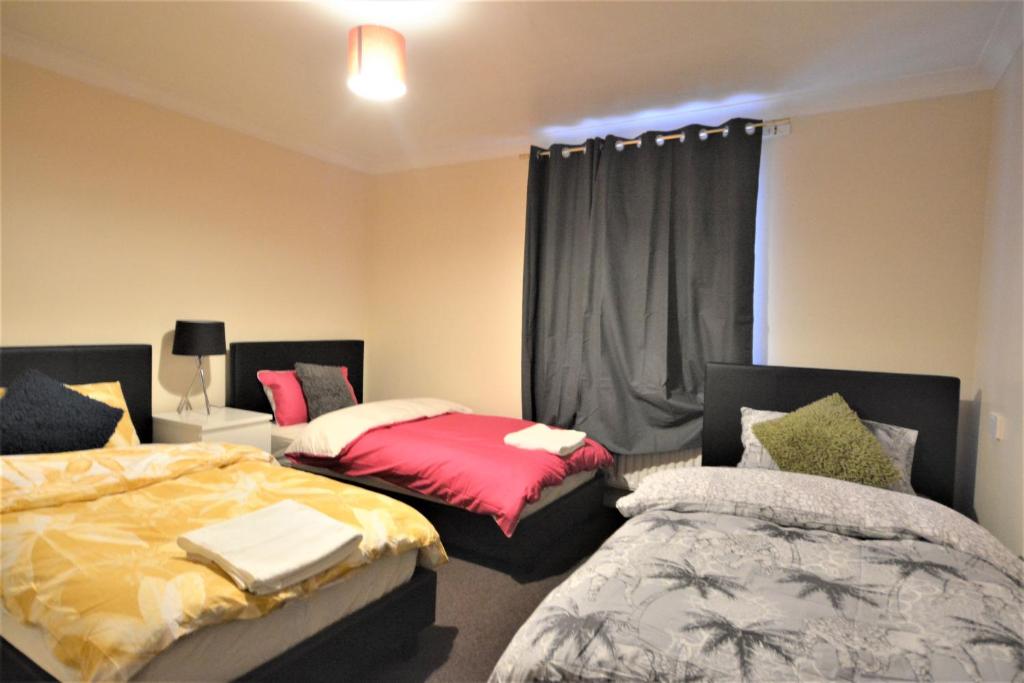 a bedroom with two beds and a window at London Zone 2 Lovely 4 bedroom Apartment - 3 Trowbridge Road in London