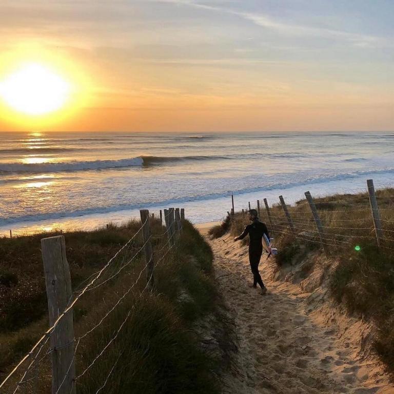 - un homme s'engageant sur un chemin sur la plage au coucher du soleil dans l'établissement Le Chai & L'écurie - Gîtes de charme entre plage et cœur de village, à Dolus-d'Oléron