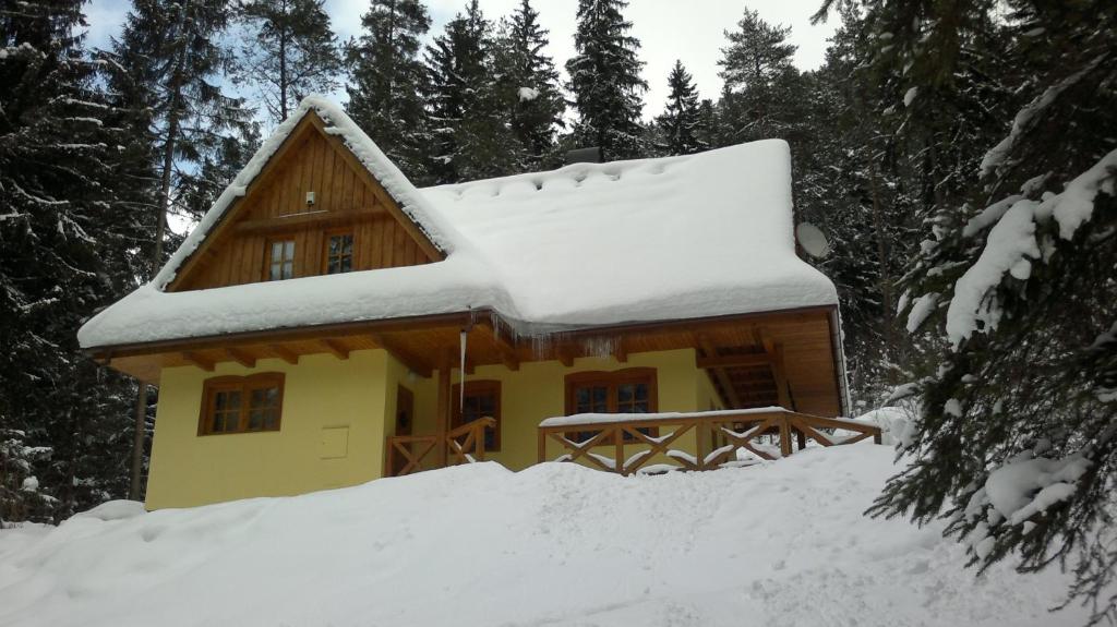 a snow covered cabin with a snow covered roof at Chata Ala in Belá