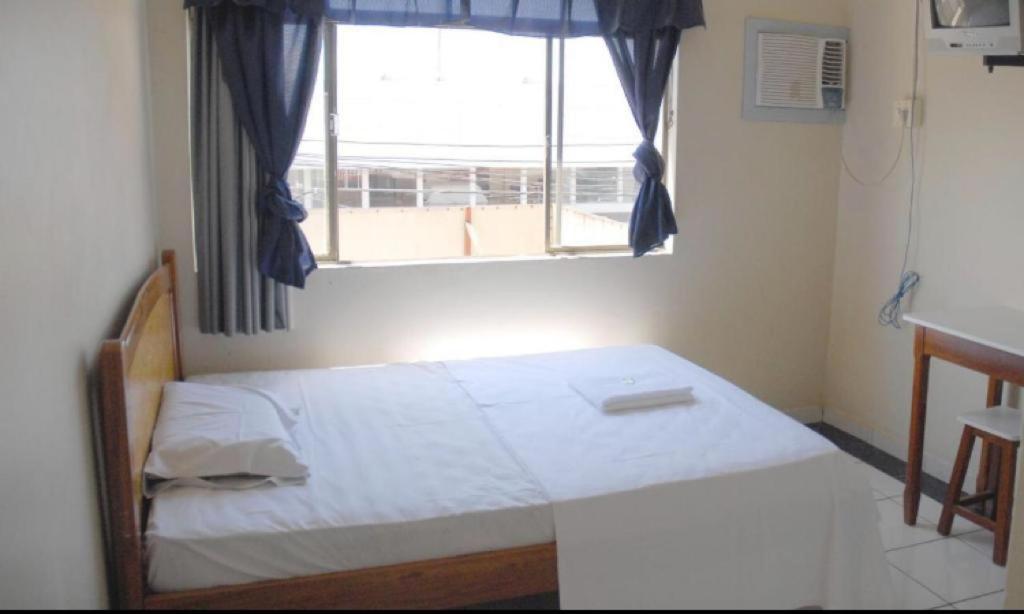 una piccola camera con letto e finestra di Hotel Cristal a Rondonópolis