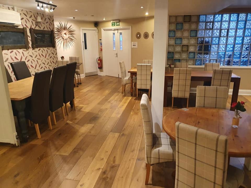 a dining room with a wooden table and chairs at The Nags Head in Norwich