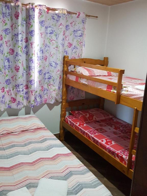 巴哈結松朱恩的住宿－Quitinete -Tamoios - Cabo Frio，一间卧室设有两张双层床和一扇窗户。