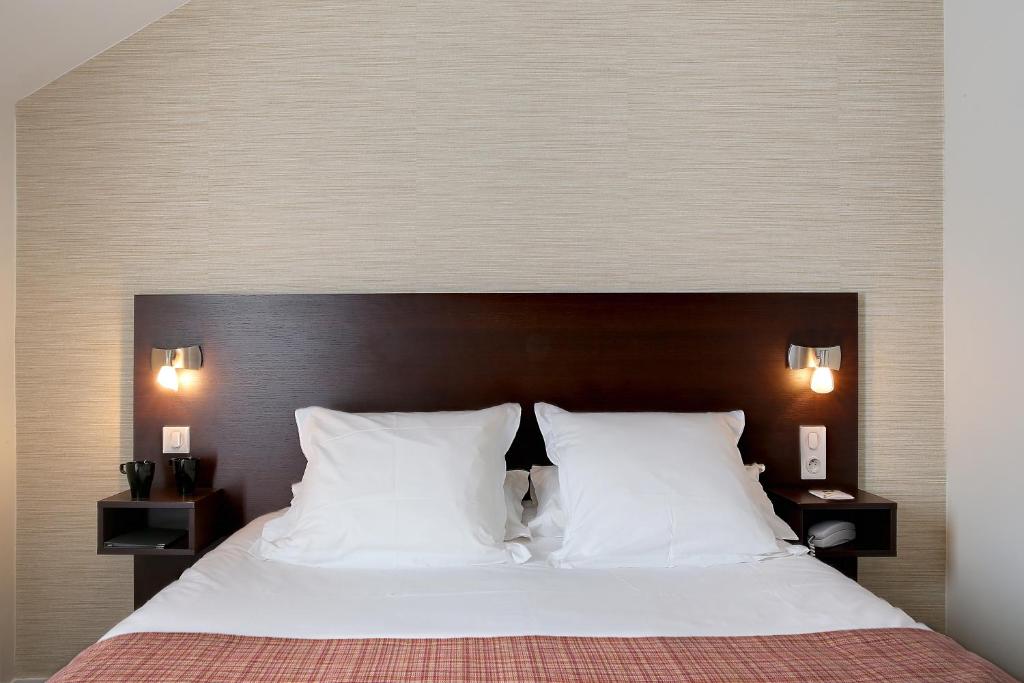 - une chambre avec un grand lit et des oreillers blancs dans l'établissement Logis Havvah Hôtel Gap, à Gap
