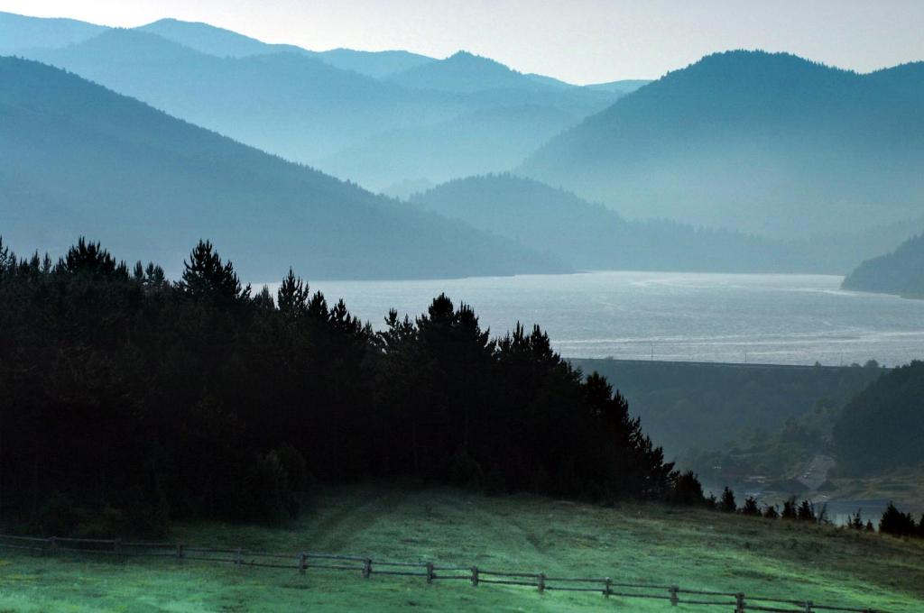a hillside with a fence and a view of the mountains at ETNO SELO VRANEŠA Zlatar in Nova Varoš