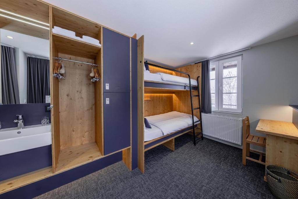 a small room with a bunk bed and a bathroom at Villars Lodge in Villars-sur-Ollon