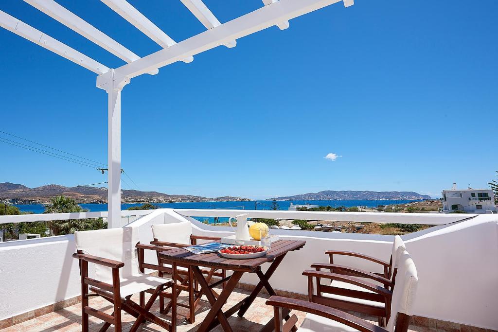 una mesa y sillas en un balcón con vistas al océano en Mirabeli Apartments & Suites, en Pollonia