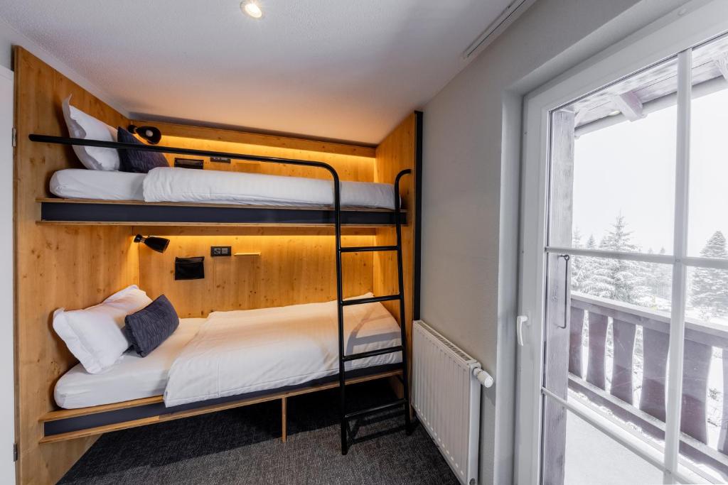 two bunk beds in a room with a window at Villars Lodge in Villars-sur-Ollon