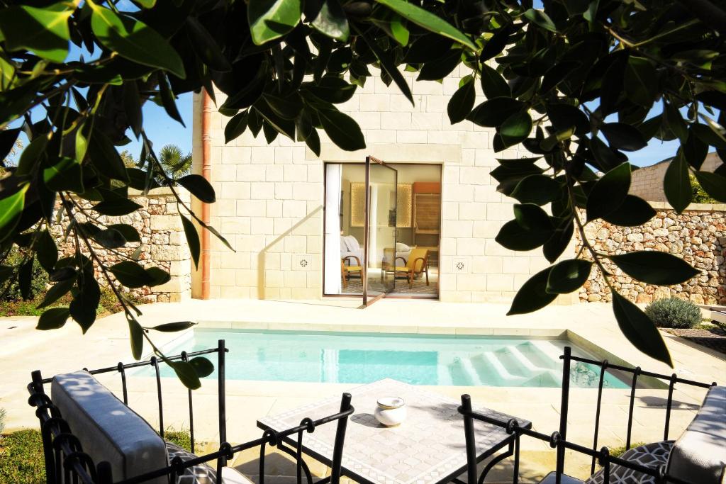 a swimming pool in front of a house at Masseria Corte degli Aromi in Palmariggi