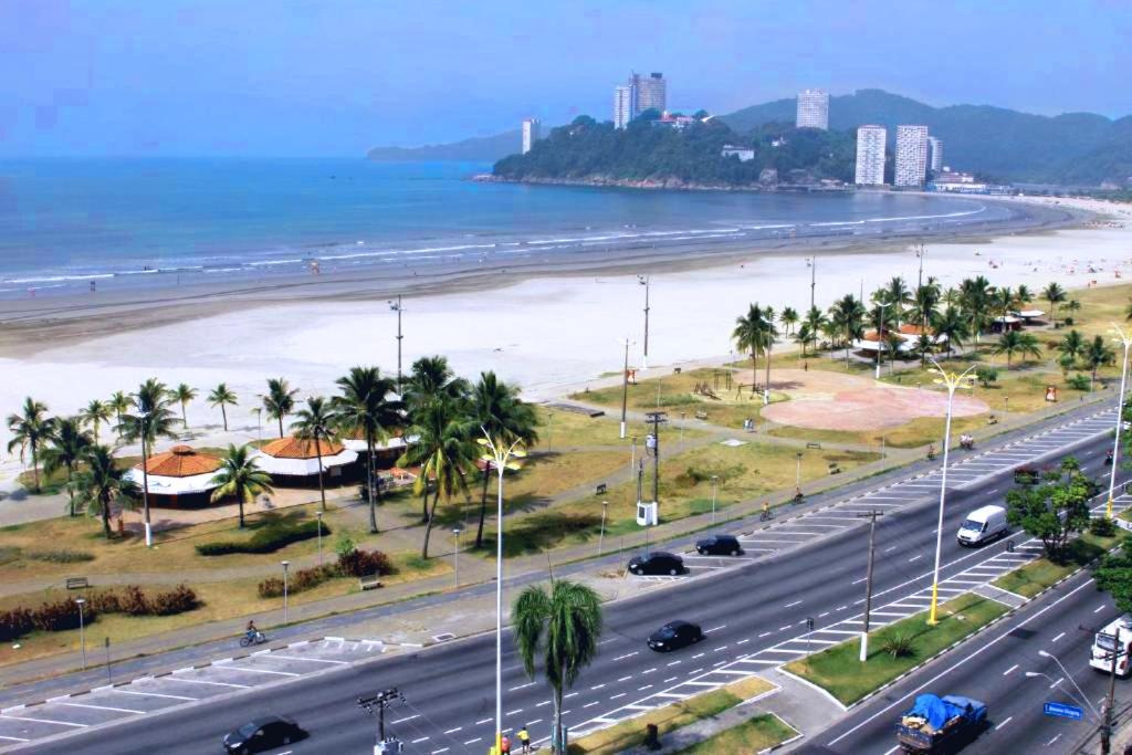 a busy highway next to a beach with palm trees at Flat Itararé Tower Beach in São Vicente